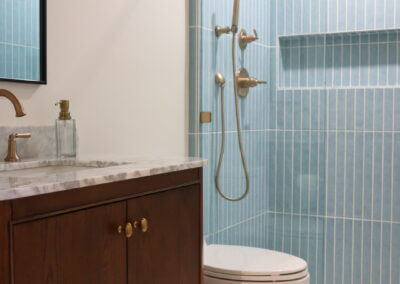 Full bathroom remodel in Camarillo, CA featuring Edward Martin Maisie Ocean tile, Reagan Dove hexagon flooring, and a Collette Cinnamon Oak vanity by All Pro Construction, Inc